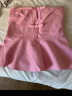 Rosa axelbandslös topp från Zara - Säljer en söt rosa axelbandslös topp från Zara med volang nertill. Använd 1 gång så inga defekter 