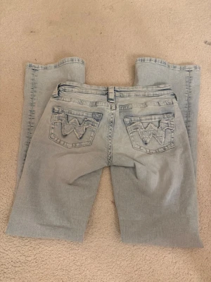 Ljusblå bootcut jeans från gina Young  - Snygga ljusblå bootcut jeans med låg midja och broderade detaljer på bakfickorna. Jeansen är lågmidjade. Använda endast en gång 