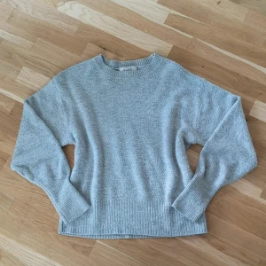 Grå mysig tröja - Mysig grå tröja från H&M med rund hals och ribbade muddar vid ärmslut och nederkant.