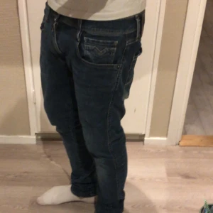 Replay Anbass mörkblå jeans - Säljer ett par Replay Anbass jeans i mörkblå tvätt med klassisk femficksdesign och smal passform. Jeansen har snygga detaljer vid fickorna och är tillverkade i stretchigt denim för extra komfort. Perfekt för dig som gillar en modern och stilren look. Ny pris 1299 mitt pris 329