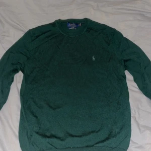 Grön merinoullströja Polo Ralph Lauren - Mörkgrön stickad tröja från Polo Ralph Lauren. Är helt nyt skick i passformen slim fit med klassisk rund hals och broderad logga på bröstet. Tillverkad i mjuk och tvättbar merinoull, perfekt för lager-på-lager under höst och vinter.