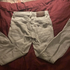 G-Star Raw Slim ljusgrå jeans - Säljer ett par riktigt feta G-Star Raw Arc 3D Slim jeans i ljusgrå färg. Jeansen har klassisk femficksdesign, snygga sömdetaljer och en slim passform. Tillverkade i jeansmaterial med G-Star patch bak i midjan. Perfekta för dig som gillar stilrena och moderna jeans. Kontakta mig vid frågor!
