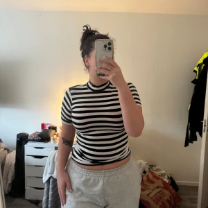 Svartvit randig polotopp Club XPRS - Säljer en svartvit randig polotopp från Club XPRS i storlek L. Toppen har korta ärmar, hög krage och är slim fit. Materialet är mjuk bomull som sitter skönt mot kroppen. Perfekt för dig som gillar en clean och edgy stil med tydliga kontraster.