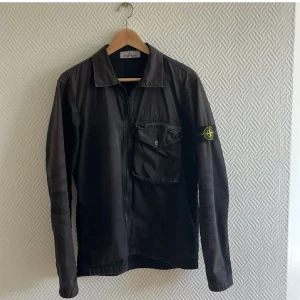 Svart overshirt från Stone Island - Skön overshirt från Stone island. Inga deffekter föutom av den är solblekt vilket man ser på bilderna. 