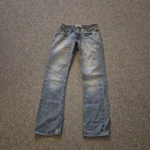 Tiger of Sweden blå jeans straight fit - Blå jeans från Tiger of Sweden med klassisk straight fit och normal passning. Jeansen har fem fickor, dragkedja och knapp framtill samt läderpatch med logga bak. Materialet är slitstarkt denim i bomull och färgen är ljusblå med snygga tvättade detaljer.