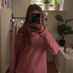 Rosa stickad tröja från Vero Moda - Mysig rosa stickad tröja från Vero Moda med rund halsringning och långa ärmar. Tröjan har en enkel och clean design med ribbade muddar vid hals, ärmslut och nederkant. Mycket använd.