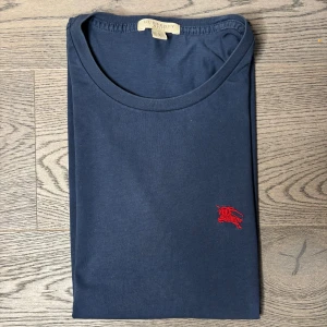 Burberry T-shirt  - Säljer en marinblå Burberry T-shirt i storleken S. T-shirten är i jätte bra skick, som ny. T-shirten är 100% äkta köpte på NK. Skulle du ha några funderingar så är det bara och skriva😊