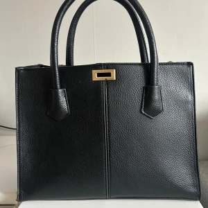 Axelväska från Gina Tricot  - Gina Tricot axelväska som inte säljs mer. Gulddetaljen i mitten har tappat lite färg och det är lite trådar som sticker ut vid banden. Priset går att diskutera!