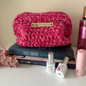 Virkad necessär (clutch bag) - Kelly -  - Virkad necessär - Kelly -    🩷 En handgjord necessär med ihopfälld         bar ram 🩷 Virkad i ett härligt chenille garn 🩷 Psst, namn etiketten går att ta bort om         så önskas 🩷 Storlek M: Bred ca 17 cm - Lång ca 22        cm  🩷 Virkad av mig @virkningbynadja  (Kolla min profil för fler färger)   Kolla gärna in min Instagram för mer, @virkningbynadja ✨