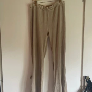 Beiga mjukisbyxor med snörning - Säljer ett par beiga mjukisbyxor med bred resår i midjan och snörning framtill. Byxorna har en rak passform och är tillverkade i ett mjukt material som känns skönt mot huden. Perfekta för en avslappnad stil.