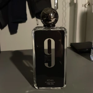Afnan 9PM Eau de Parfum 100ml - Stilren parfym med modern design från Afnan. Flaskan rymmer 100ml och passar dig som vill sticka ut med en elegant touch. Perfekt för dig som gillar att uttrycka din personlighet med en unik doft. Ungefär 90+ml kvar! Orderbekräftelse kan jag ta fram om äkthet är en fråga!