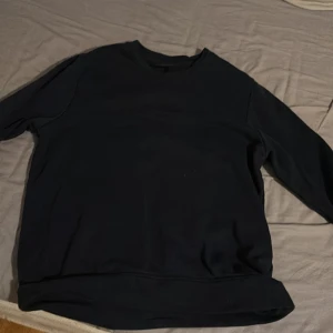 Mörkblå sweatshirt från Peak Performance XS - En stilren svart sweatshirt från Peak Performance i storlek XS. Tröjan har rund halsringning och långa ärmar, perfekt för en clean och enkel look. Tillverkad i mjukt material som känns skönt mot huden.