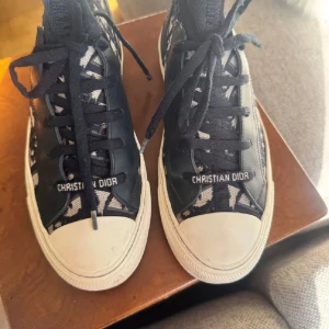 Christian Dior svarta high-top sneakers - Så fina Christian dior sneakers, inköpta i maj 2025 från Vestiaire Collective, bevis från köpet kan skickas privat. Bra skick! Dustbag, box och extra par skosnören nedkommer. Storlek 37! Marinblå/svart färg.