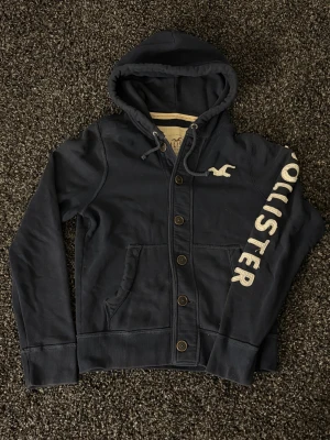 Hollister cardigan - sjukt eftertraktad! - 🔥 Extremt eftertraktad Hollister-hoodie, stl L/M, skick 8/10 🔥 Black Week-REA! Passa på medan priset är sänkt – det här är en av Hollisters mest populära modeller och den dyker nästan aldrig upp. Sitter perfekt, sjukt snygg och funkar till ALLT.  Den här kommer försvinna direkt – folk brukar köpa såna här på sekunder. Först till kvarn. Köp nu innan någon annan hinner före!  Ta liknande som den