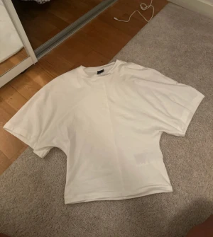 Vit oversized t-shirt - En basic vit t-shirt med oversized passform och korta ärmar. Perfekt till jeans eller shorts för en avslappnad look. Tillverkad i mjuk bomull för maximal komfort.