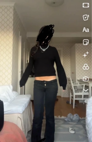 Svart croppad stickad tröja - Svart croppad stickad tröja med långärmad passform och v-ringad hals. Tröjan har en loose fit och är perfekt att matcha med både jeans och smycken för en chill och snygg look. Enkel design utan mönster eller extra detaljer.