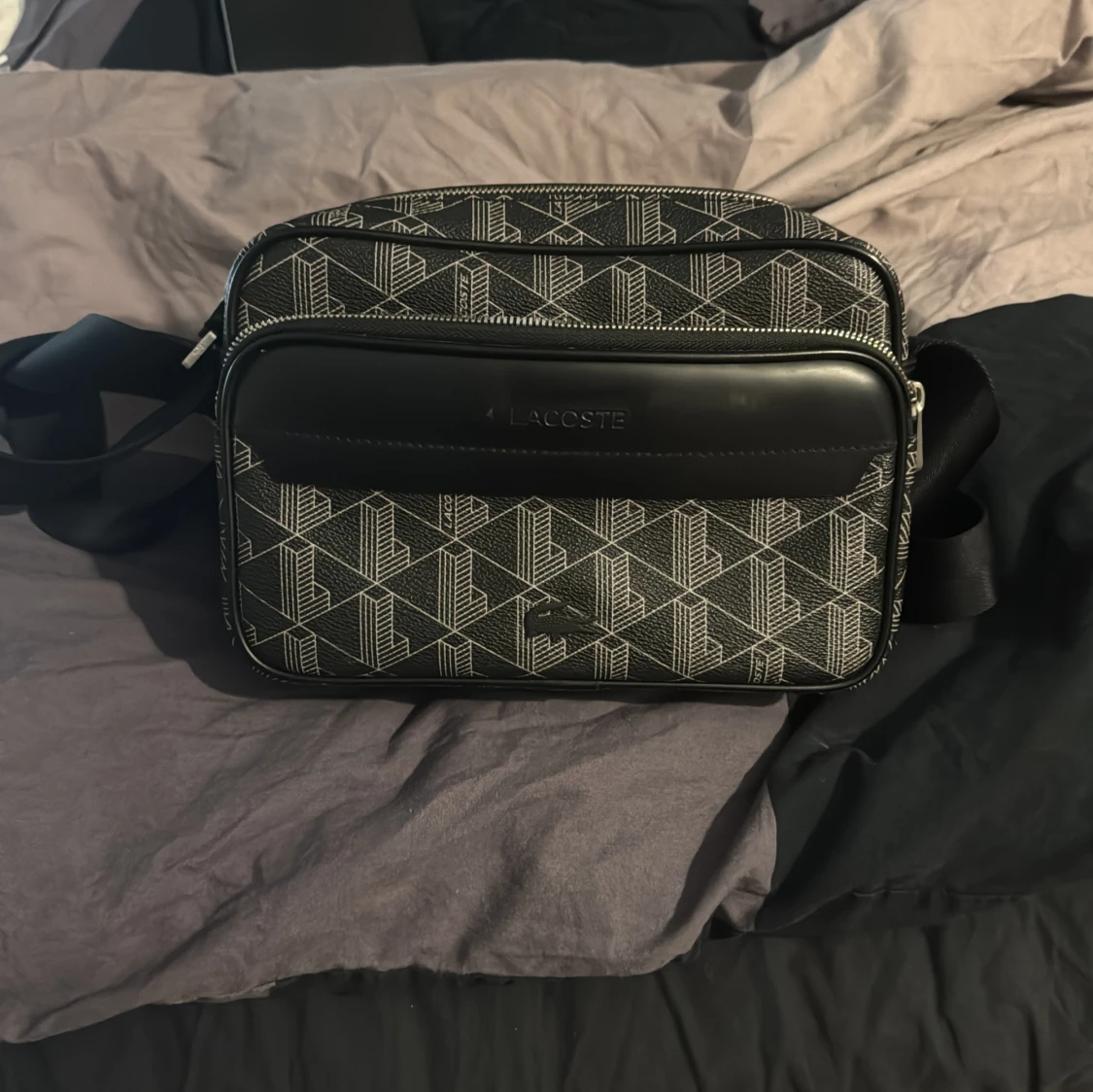 Svart axelväska från Lacoste med mönster