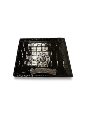 Svart plånbok från Chrome Hearts - Snygg svart plånbok från Chrome Hearts med croco-mönstrad yta och silverfärgad metallapplikation framtill. Plånboken har flera kortfack och en stilren, lyxig vibe som passar perfekt i fickan. Materialet är skinn med glansig finish och detaljer i metall.