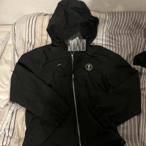 Trapstar windbreaker - Fin trapstar windbreaker. Den passar Xs och S. Använd ett fåtal gånger. Priset är ej hugget I sten. Det är bara att fråga på. Saknar metall tip på ett snöre