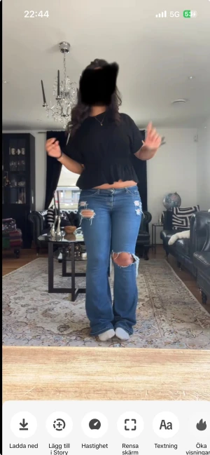 Blå bootcut jeans med slitningar - Säljer ett par blå bootcut jeans med snygga slitningar och hål på låret och vid fickorna. Jeansen har låg midja och är tillverkade i klassiskt denimtyg. Perfekta för dig som gillar en avslappnad och trendig look.