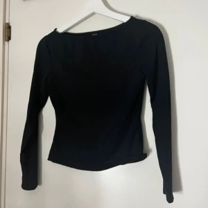 Svart långärmad topp med båtringning - En stilren svart långärmad topp från C&A med båtringad hals. Modellen är figurnära och har en enkel, clean design utan mönster eller detaljer. Perfekt att matcha med jeans eller kjol för en snygg look.