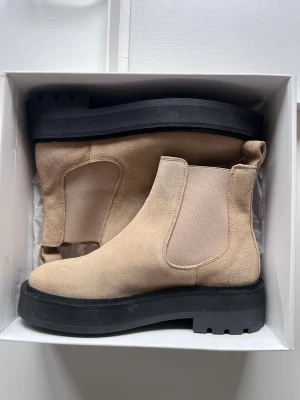Beige chelsea boots från &Other Stories.  - Helt nya chelsea boots i beige mocka från &Other Stories. Perfekta för dig som gillar stilrena boots med lite extra edge. Oanvända i originalkartong.                Nypris 1 450kr!