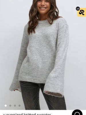 Grå oversized stickad tröja Gina Tricot - Mysig grå stickad tröja från Gina Tricot i oversized modell. Tröjan har långa ärmar, rund halsringning och ribbade muddar vid ärmslut och nederkant. Perfekt för lager-på-lager och chill dagar.