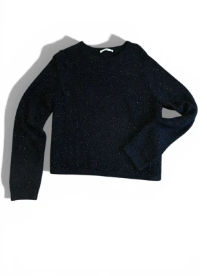 Svart glittrig stickad tröja - Säljer en svart stickad tröja med glittriga inslag. Tröjan har rund halsringning och långa ärmar. Perfekt för dig som vill ha en enkel men ändå lite extra look till hösten eller vintern. 