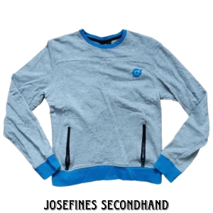 Grå mjukiströja med fickor - Grå mjukis/träningströja från Woxo. Har  fickor med dragkedjor och blåa detaljer. Är jätteskön och i fint skick