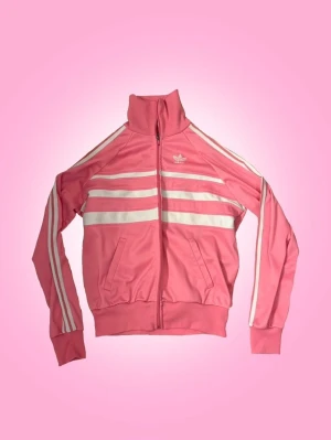 Vintage Rosa Adidas Set  - Vintage rosa Adidas set. Setet är välanvänt men ingen större defekt. Enda är att dragskedjorna tappat lite färg och kan vara lite tröga, de går fortfarande att stänga. Skulle du endast vilja köpa ett av plaggen så får du skicka dm. Priset på annonsen gäller för båda plaggen tillsammans💕   Övrig information: -fraktar torsdagar, fredagar och lördagar -jag står inte för fraktens slarv -priset går alltid att diskuteras via dm -skriv privat för övriga frågor eller om du vill ha fler bilder