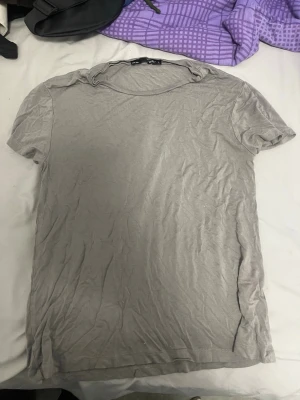 Grå basic t-shirt från 157 - Enkel grå t-shirt från 157 med rund hals och korta ärmar. Tillverkad i mjuk bomull som känns skön mot huden. Perfekt till jeans eller shorts för en clean och avslappnad look.