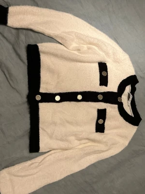 Vit och svart croppad kofta med guldknappar - As snygg kofta! 