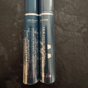 Oriflame The One Wonder Lash XXL Mascara - Två tuber Oriflame The One Wonder Lash XXL Mascara i blå metallic-förpackning. Vattenfast formula som ger extra volym och längd till fransarna. Snygg och stilren design, perfekt för att skapa dramatiska ögonfransar. En av de oöppnad den andra används bara en gång.