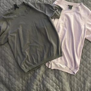 Två stickade kortärmade tröjor Lindex S - två stickade tröjor från Lindex i storlek S. Ena tröjan är mörkgrå med rund hals och ribbade detaljer, den andra är ljusrosa med samma stil. Båda har korta ärmar och mjukt material som känns skönt mot huden. Knappt använda💕💖