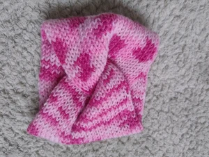 Rosa stickat twistat pannband - Säljer ett snyggt stickat pannband i olika rosa nyanser med twistad front som jag gjort själv. Perfekt för att hålla öronen varma och samtidigt se stylish ut i vinter.