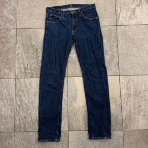 Lee jeans  - Snygga mörkblå jeans från Lee, modell Daren Zip Fly. Klassisk femficksdesign med gul kontrastsöm och Lee-logga på bakfickan. Rak passform och zip-fly. Perfekta för dig som gillar stilrena och tidlösa jeans. Hör av dig vid frågor och funderingar!