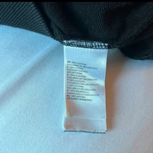 Svart hoodie från The North Face M - Svart hoodie från The North Face i storlek M. Tröjan har broderad logga framtill, huva med snörning och en stor magficka. Tillverkad i 100% bomull för skön känsla. Perfekt för chill dagar och streetwear-stil.