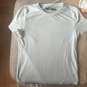 Ljusblå t-shirt från Bik Bok XS - Snygg ljusblå t-shirt från Bik Bok i storlek XS. Modellen är klassisk med rund hals och korta ärmar. Tillverkad i mjuk bomull som känns skön mot huden. Perfekt att matcha med jeans eller shorts för en chill look.