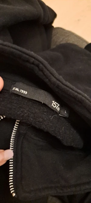 Svart fleecejacka från 157 L - Svart fleecejacka med rak passform och hög krage från 157. Jackan har en hel dragkedja framtill och är tillverkad i mjuk fleece som håller dig varm. Perfekt för kyliga dagar och enkel att slänga på över en hoodie. Stilren och enkel design utan mönster.