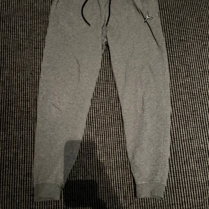 Grå Jordan Mjukisbyxor - Säljer ett par sköna och mjuka Jordan mjukisbyxor som är perfekta att använda vardagligt som antingen träningsbyxor eller som sköna mysbyxor hemma. Är använda fåtal gånger och har inga defekter eller skador.