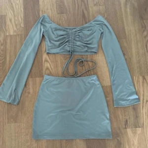 Grå kortkjol i stretchigt material - Snygg grå kortkjol i stretchigt och mjukt material. Kjolen har en enkel, tight passform och passar perfekt till crop tops eller oversized tröjor. Färgen är en dämpad grå nyans som är lätt att matcha med andra plagg.