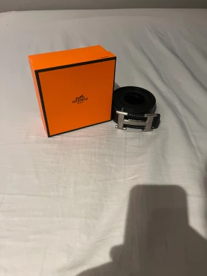 Bälte - Svart bälte med silvrigt spänne.