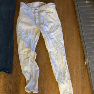 Vita jeansbyxor från Jack & Jones - Snygga vita jeansbyxor från Jack & Jones med klassisk femficksdesign och knappgylf. Byxorna har en rak passform och är tillverkade i bomullsmaterial. Perfekt för dig som vill sticka ut med en fräsch och stilren look.
