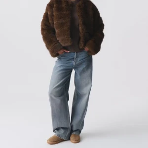 Brun pälsjacka från Gina Tricot - Säljer en brun pälsjacka från Gina Tricot med croppad passform och rund hals. Jackan har ett fluffigt och mjukt material som ger en lyxig vibe. Perfekt för dig som vill sticka ut med en trendig look. Långärmad och fodrad för extra komfort.