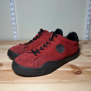 Eytys Wave Suede  - Eytys Wave Suede. Röda sneakers i mjuk mocka med svart gummisula och svarta snören. Rund tå och låg profil, med Eytys-logga på sidan. 