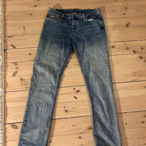 Blå jeans från Monten i storlek 34/34 - Snygga blå jeans från Manten i klassisk femficksmodell. Jeansen har en slim fit och är tillverkade i slitstarkt denim. Storlek 34/34.