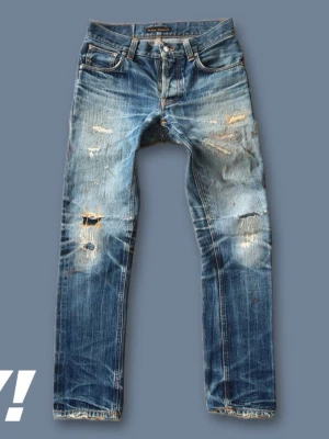 Nudie Grim Tim selvedge 29:32 reserverad för Christian - the sickest jeans I've ever seen and by far the sickest this drop, perfect worn condition, everything is fixed by nudies repair shop except for a small cut on the left knee. Small paint spots on the thighs that give the jeans extra character. They have special repairs on the thighs by nudie repair shop. IB-Length: 74cm YB-Length: 101cm Waist: 38cm Thigh: 22cm Leg opening: 16cm DM me with any questions. Reserverade för Christian