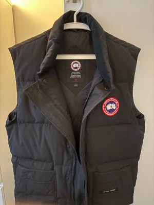 Canada Goose väst i TOPPSKICK – Äkta, kvitto finns - Säljer min Canada Goose väst i suveränt nyskick.    ✔️ 100% ÄKTA – kvitto finns som bevis ✔️ Köpt 2023 ✔️ Endast använd 2–3 gånger ✔️ Har mest hängt i garderoben ✔️ Inga fläckar, slitage eller defekter ✔️ Ser i princip helt ny ut.