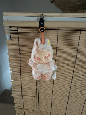 Labubu rosa vit gul - Säljer en supergullig ljusrosa labubu med fluffig look och små öron.  har en mjuk och mysig känsla, perfekt för dig som gillar söta detaljer. Märket The Monsters syns på etiketten. Passar dig som vill sticka ut med något unikt.