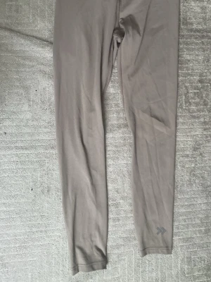 Ingen sko syns på bilden - Bilderna visar ett par gråa tights eller leggings, inte skor. Ingen information om skor kan ges utifrån dessa bilder.